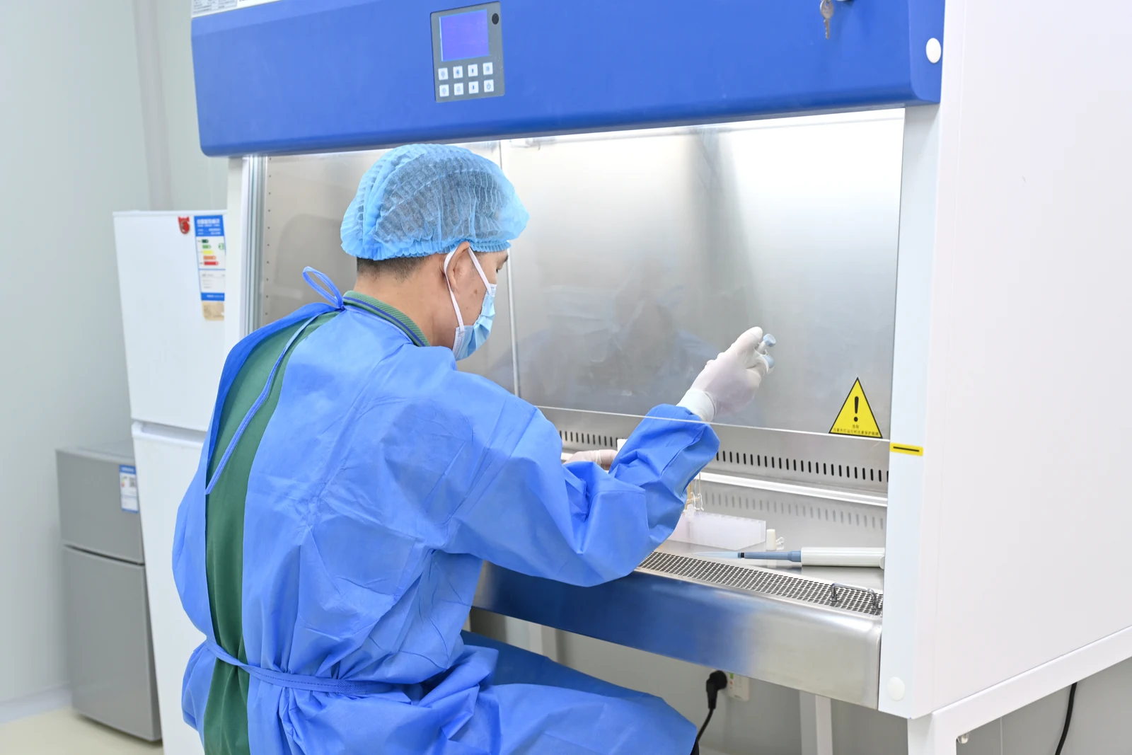 Laboratory staff working at a safety cabinet in VanTsteri’s microbiology laboratory